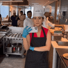 a woman in a chef 's hat takes a picture of herself