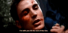 a close up of a man with blood on his face and the words `` i 'm with you till the end of the line . ''