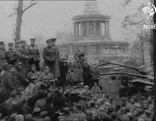 a group of soldiers are gathered in front of a building with the word pathe on the bottom