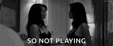 two women in lingerie are standing next to each other and the words `` so not playing '' are visible .