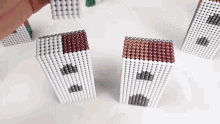 a person is playing with a set of magnet beads that look like buildings