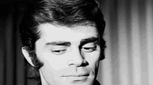a black and white photo of a man 's face with a beard .