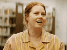a woman in a striped shirt is smiling with her mouth wide open
