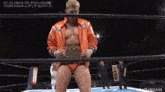 a wrestler in an orange jacket with the word climax on the front