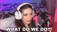 a woman wearing headphones is sitting in front of a microphone and says `` what do we do '' .