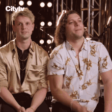two men sitting next to each other with the citytv logo on the bottom