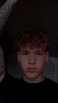a man with a tattoo on his arm is taking a picture of himself