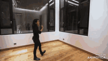 a woman is walking in an empty room with the words made in animotica above her