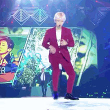 a man in a red suit is dancing on a stage in front of a sign that says ' er '