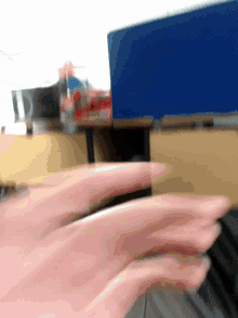 a blurry picture of a person 's hands in front of a blue wall