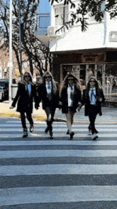 four women are crossing a street in front of a building that says gaucho market