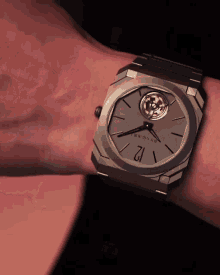 a person is wearing a bvlgari watch on their left wrist