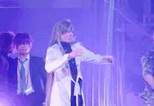 a man in a white coat with a cross on his chest is dancing on a stage