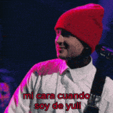 a man wearing a red beanie and a white shirt says mi cara cuando soy de yuli