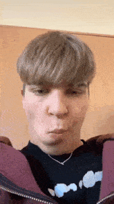 a young man is making a funny face with his mouth open .