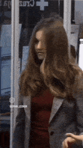 a woman with long hair is standing in front of a sign that says spain_leonor