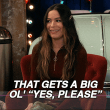 a woman sits in a red chair with the words that gets a big ol " yes please "