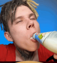 a young man with dreadlocks is drinking from a bottle with a label that says ' yogurt ' on it