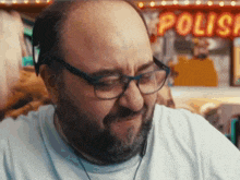 a man with glasses and a beard is sitting in front of a sign that says polio