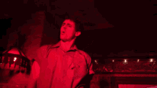 a man in a red shirt has a badge on his chest that says ' a ' on it
