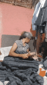 a woman is laying on a bed with a blanket and a book