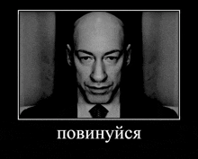 a black and white photo of a bald man in a suit and tie with the caption " повинуйся "