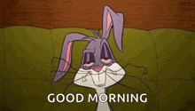 bugs bunny from looney tunes is laying on a couch with his eyes closed .
