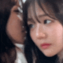 a close up of two girls kissing each other .