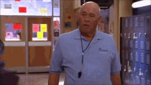 an older bald man wearing a blue shirt with the name russell on it