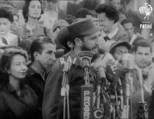 a black and white photo of a man speaking into a microphone with the word progresso on it