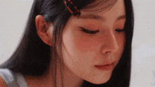 a close up of a woman 's face with a clip in her hair