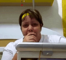 a woman wearing a headband is sitting in front of a laptop computer