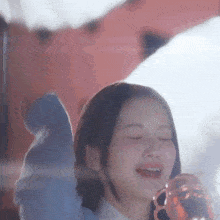 a woman is singing into a microphone with her eyes closed