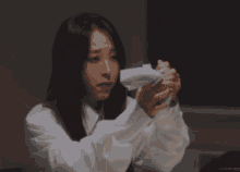 a woman in a white sweatshirt is making a funny face
