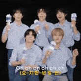 a group of young men are posing for a picture and one of them is holding a light stick that says oh oh oh oh on it