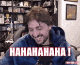 a man with a beard is laughing in front of a microphone with the words ' hahahaha ! ' in red