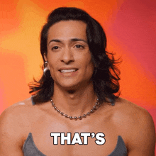 a man with long hair and a necklace smiles and says that 's