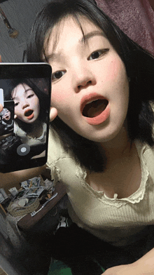 a girl is taking a selfie with her mouth open