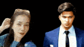 a man in a suit and tie stands next to a woman in sunglasses