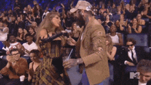 a man and woman are hugging in front of a crowd with a mtv logo in the background