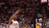 a basketball player wearing a cavs jersey throws a ball in the air