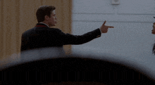 a man in a suit and a woman in a black hat are dancing together