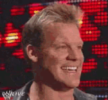 a close up of a man 's face with his eyes closed and a w live logo in the background .