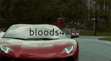 a red sports car with bloods4life written on the windshield