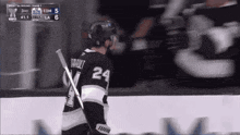a hockey player wearing a number 24 jersey stands on the ice