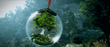 a sphere with a tree inside of it hanging from a rope