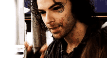 a man with blood on his face is looking at the camera