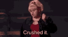 a woman in a red shirt is dancing with the words crushed it written below her