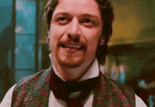 a man with a beard and mustache is wearing a vest and bow tie .