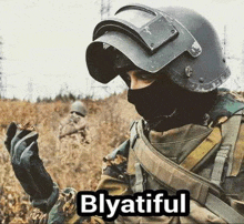 a soldier wearing a helmet , mask and gloves is holding a piece of wood in his hand .